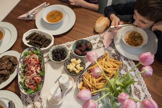 Kinder und Eltern nehmen während des heiligen Fastenmonats Ramadan ein gemeinsames Fastenbrechen-Essen in ihrer Wohnung ein.