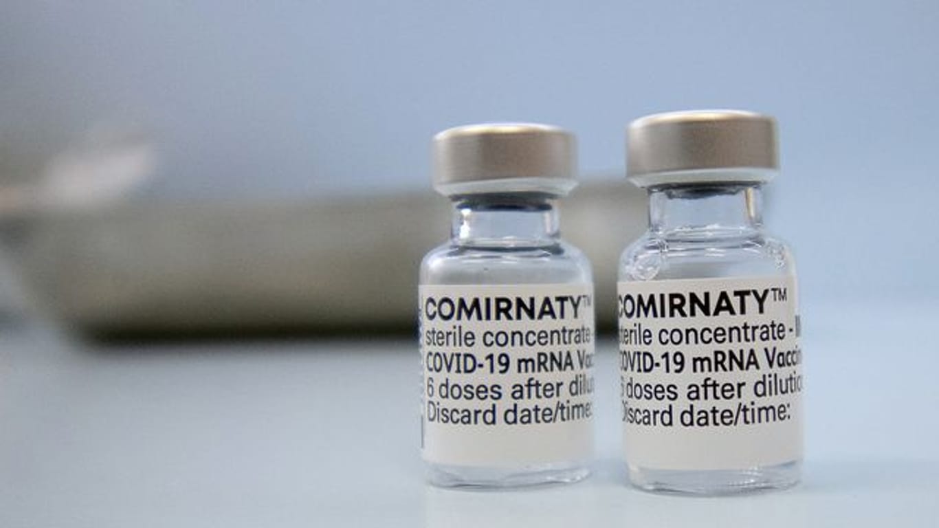 Fläschchen mit dem Biontech-Impfstoff Comirnaty stehen auf einer Theke in einer Hausarztpraxis.