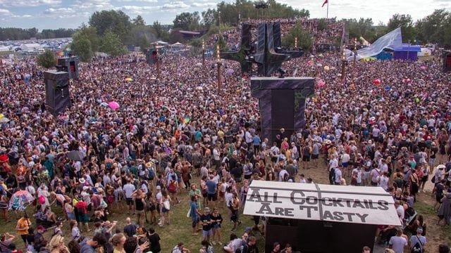 Besucher tanzen vor der Hauptbühne des vom Verein Kulturkosmos organisierten Fusion-Festivals 2019.