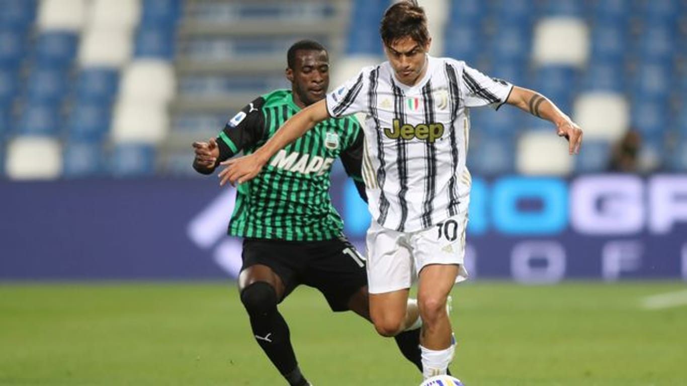 Juventus Turins Paulo Djbala (r) setzt sich gegen Sassuolos Pedro Obiang durch.
