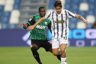 Juventus Turins Paulo Djbala (r) setzt sich gegen Sassuolos Pedro Obiang durch.