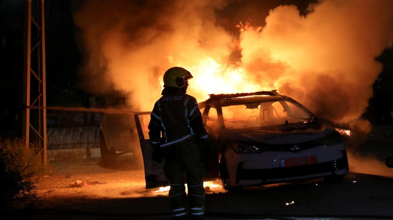 Lod, Israel: Israelische Feuerwehrleute löschen ein brennendes Auto.