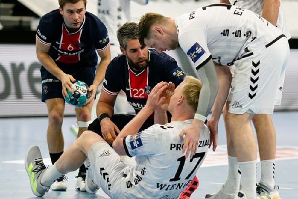 Die Pariser Spieler Luc Steins (l-r) und Luka Karabatic und Kiels Niclas Ekberg (r) kümmern sich um den verletzten Patrick Wiencek.