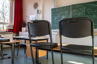 Hochgestellte Stühle in einem leeren Klassenzimmer einer Gesamtschule.
