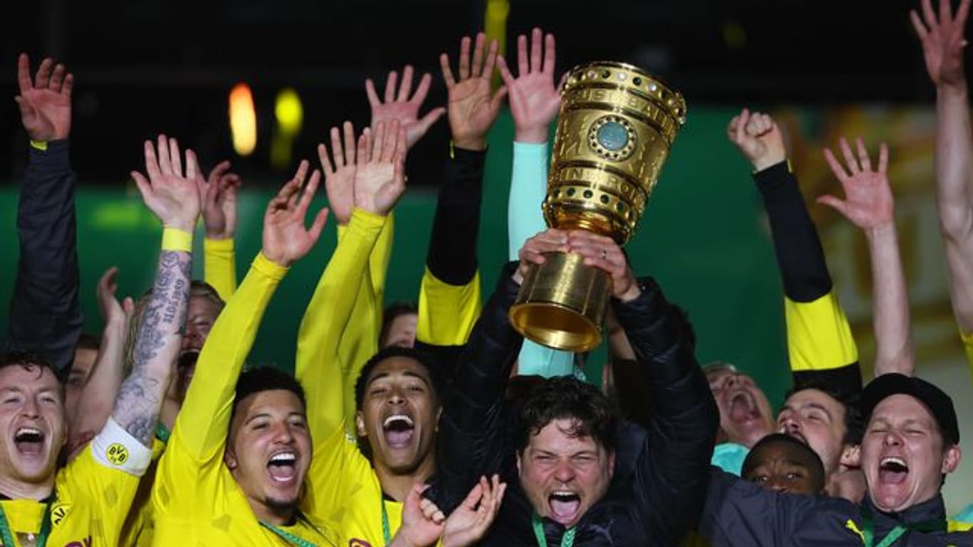 BVB-Coach Edin Terzic streckt den DFB-Pokal in den Berliner Nachthimmel.