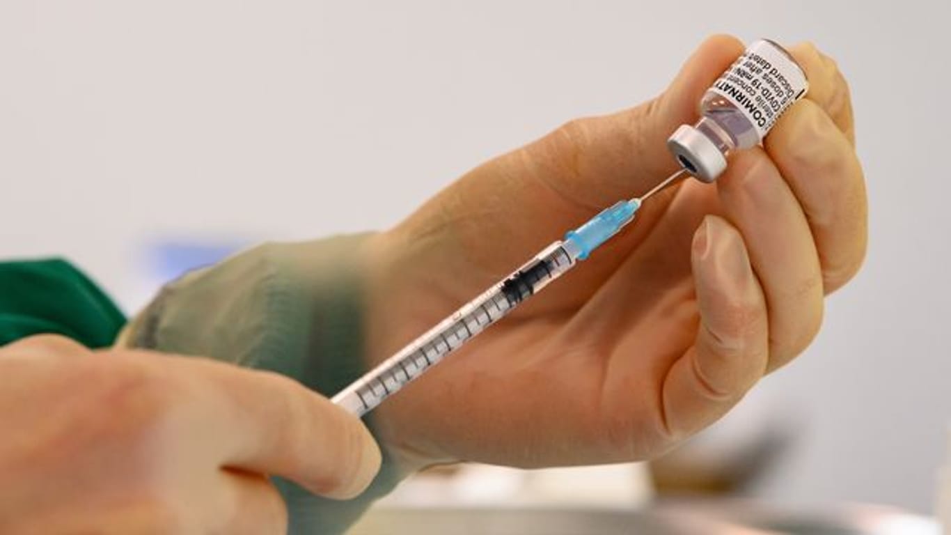 Eine pharmazeutisch-technische Assistentin zieht eine Spritze mit dem Corona-Impfstoff von Biontech/Pfizer auf.