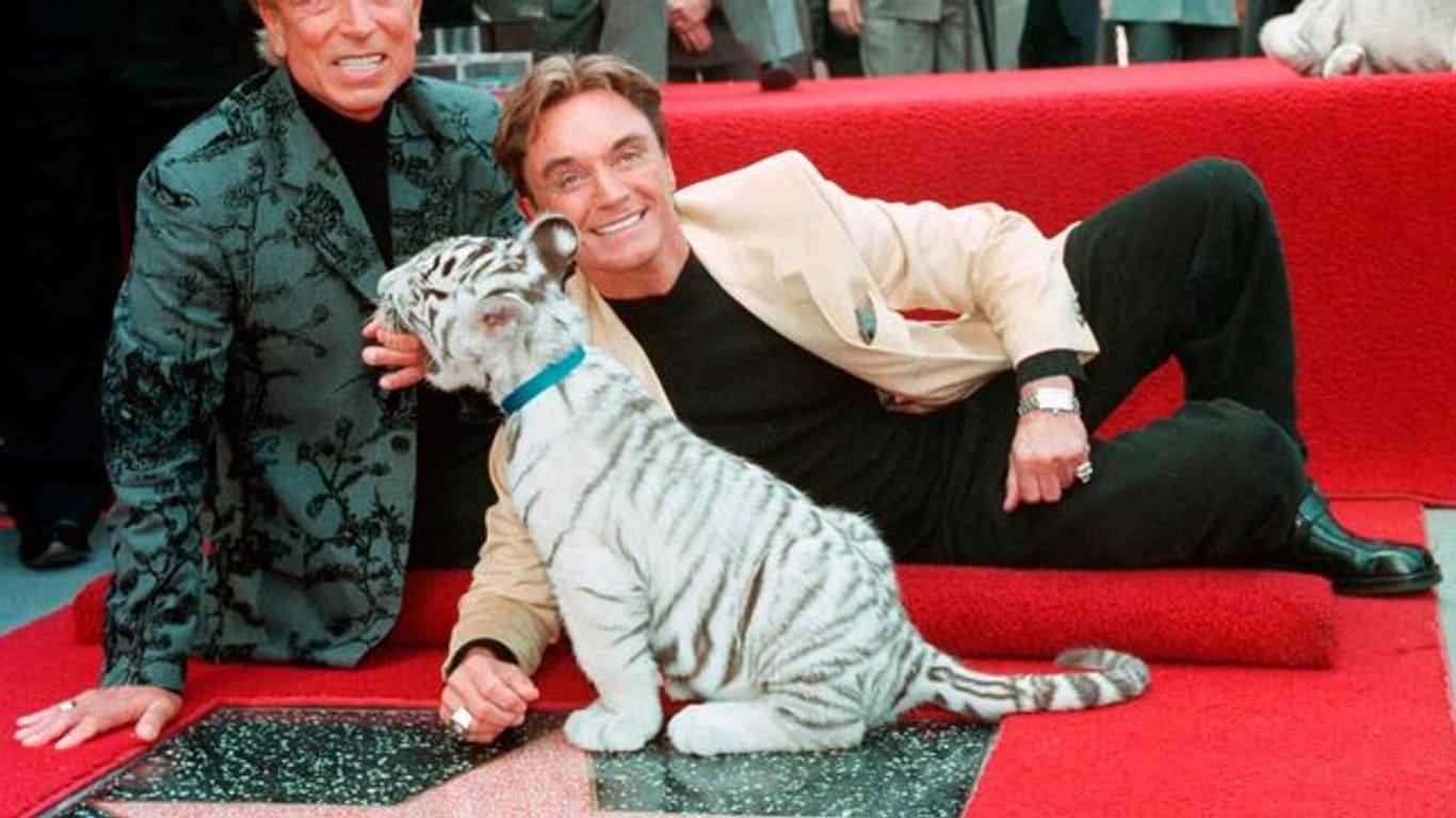 Siegfried Fischbacher (l) und Roy, Uwe Ludwig Horn, 1994 mit einem weißen Tigerbaby auf ihrem Stern auf dem Hollywood Walk of Fame.