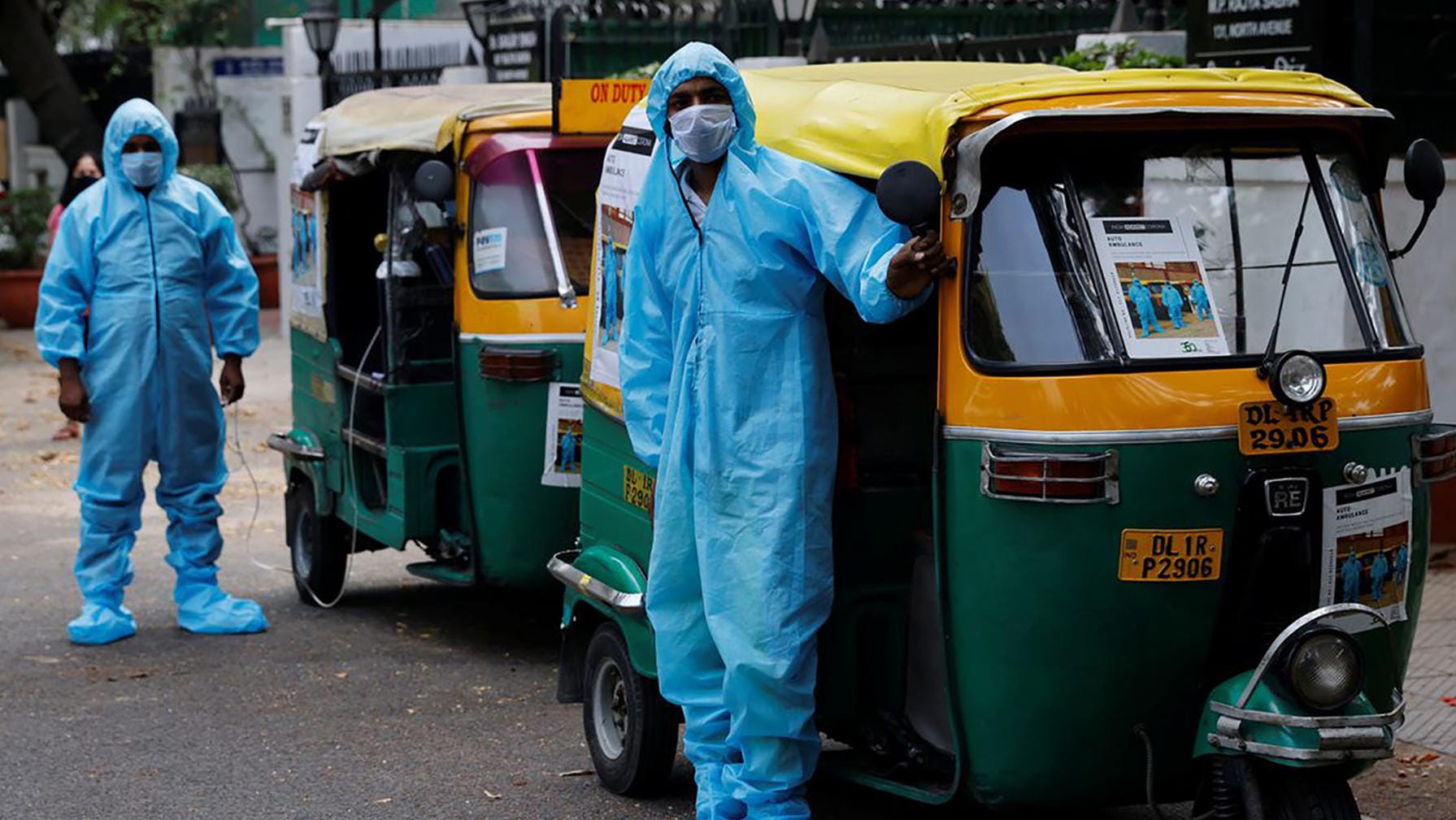 Fahrer von Rikscha-Krankenwagen in Schutzanzügen und mit Mund-Nasenschutz: Sie fahren Corona-Patienten gratis durch die indische Hauptstadt Neu Delhi.