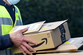 Ein Amazon-Zusteller bei der Auslieferung: Für das boomende Geschäft braucht Amazon mehr Mitarbeiter – für Geimpfte gibt es in den USA einen Bonus.