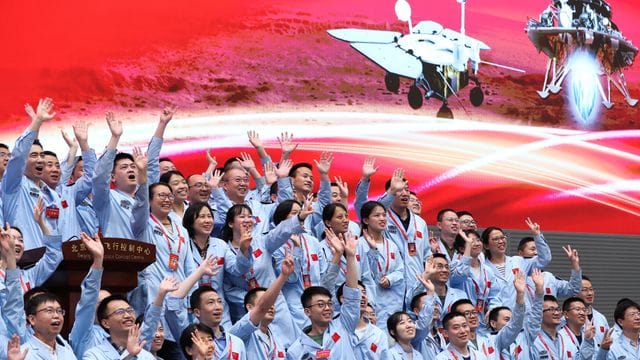 Technisches Personal im Pekinger Raumfahrtkontrollzentrum feiert die erfolgreiche Landung der chinesischen Sonde Tianwen-1 auf dem Mars.