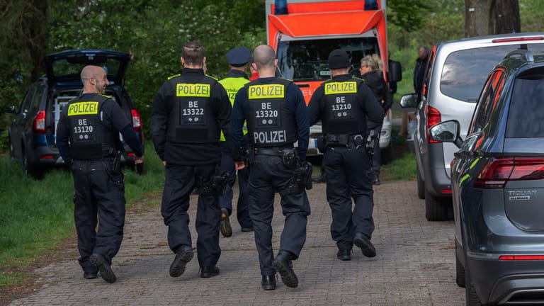 Polizeibeamte gehen auf einen Weg zu einer Parkanlage an der Idsteiner Straße Ecke Seibtweg in Berlin-Zehlendorf: Bei einem Streit ist ein 19-Jähriger ums Leben gekommen.
