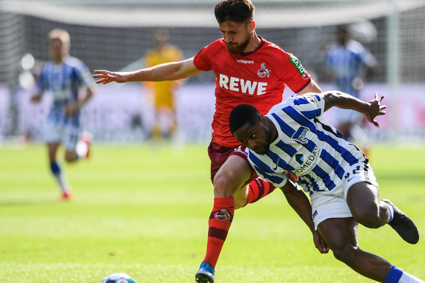 Kölns Salih Özcan (li.) und Herthas Deyovaisio Zeefuik in Aktion. Die Berliner sicherten sich mit dem Punkt den Klassenerhalt, der FC muss weiter zittern.