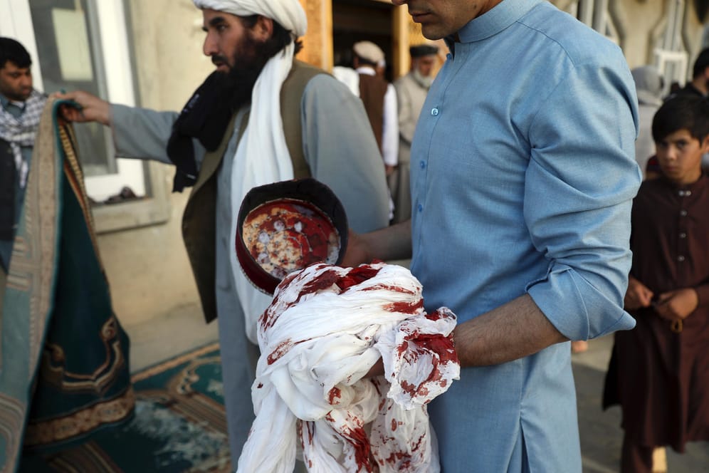 Ein Mann hält einen blutbefleckten Turban: Bei der Bombenexplosion in einer Moschee in Kabul sind zwölf Menschen ums Leben gekommen.
