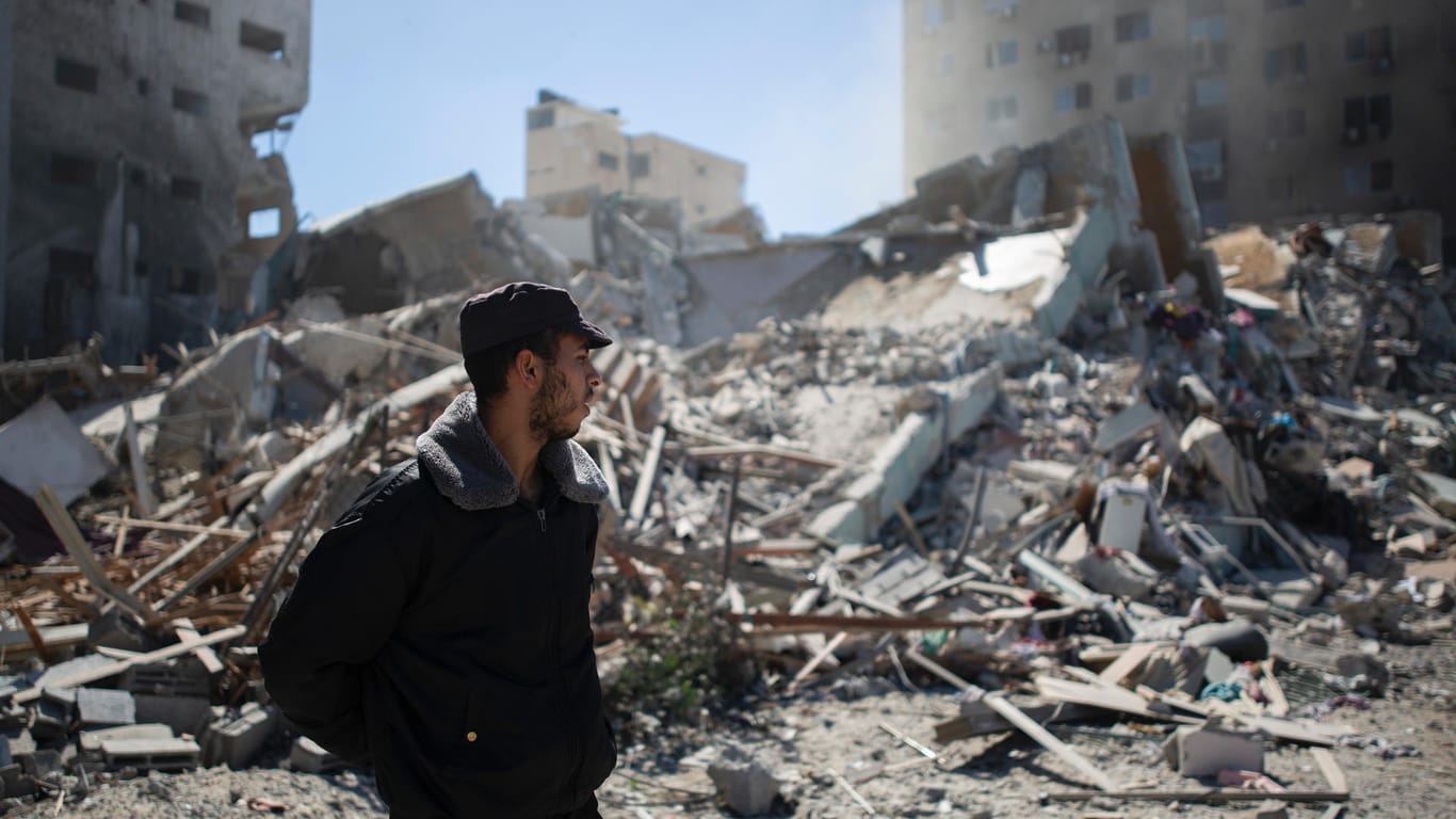 Ein palästinensischer Polizist steht vor Trümmern: Tausende Raketen wurden bisher abgefeuert.