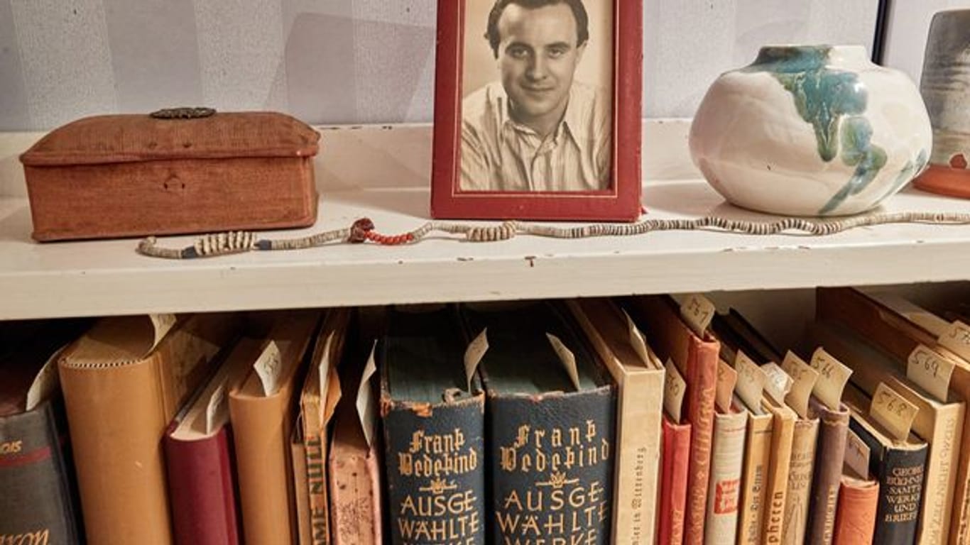 Ein Bilderrahmen mit einem Foto des Schriftstellers Wolfgang Borchert steht auf einem Bücherregal in der "Borchert-Box".