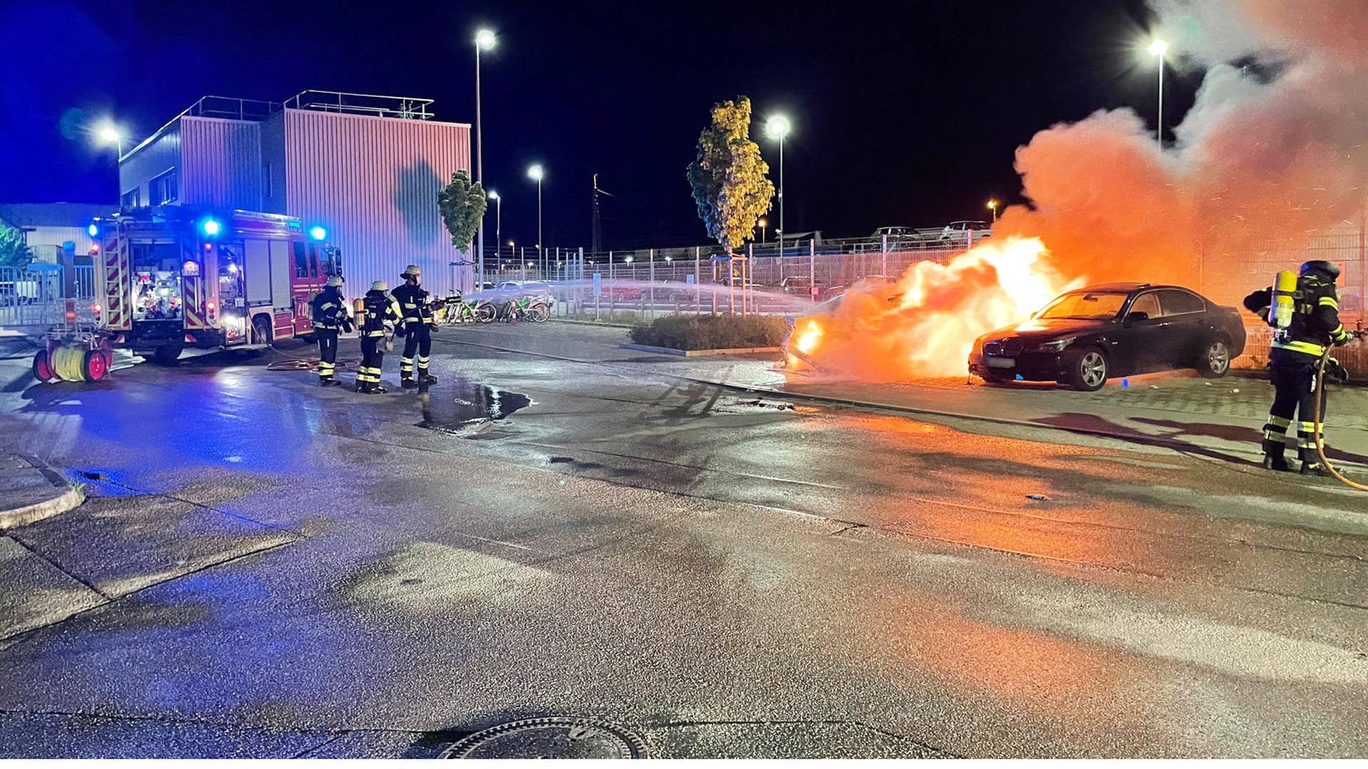 Die Feuerwehr löscht das brennende Auto: Der Wagen daneben wurde ebenfalls stark beschädigt.