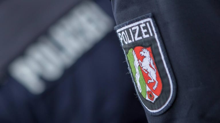 Wappen der Polizei NRW auf einer Dienstjacke (Symbolbild): In Leverkusen wurde ein 35-Jähriger von einem Mann mit Schusswaffe überfallen.
