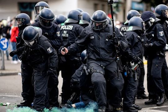Die Polizei halten eine Teilnehmerin der Demonstration verschiedener palästinensischer Gruppen in Neukölln fest.