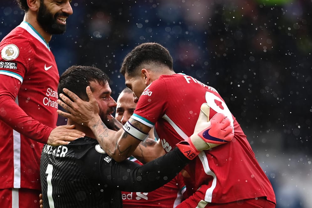 Die Liverpooler Mannschaftskollegen beglückwünschen Torwart Alisson zum Siegtreffer geben Wet Brom.