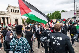 Polizeibeamte suchen am Samstag bei einer Demonstration in München nach antisemitischen Plakaten.