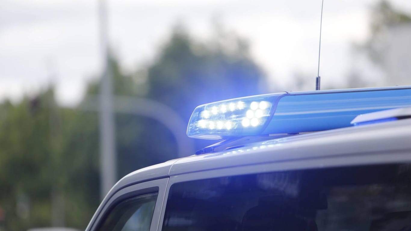 Ein Blaulicht leuchtet auf einem Polizeiauto (Symbolbild): Die Polizei hat die Ermittlungen wegen Brandstiftung, Sachbeschädigung und Volksverhetzung aufgenommen.