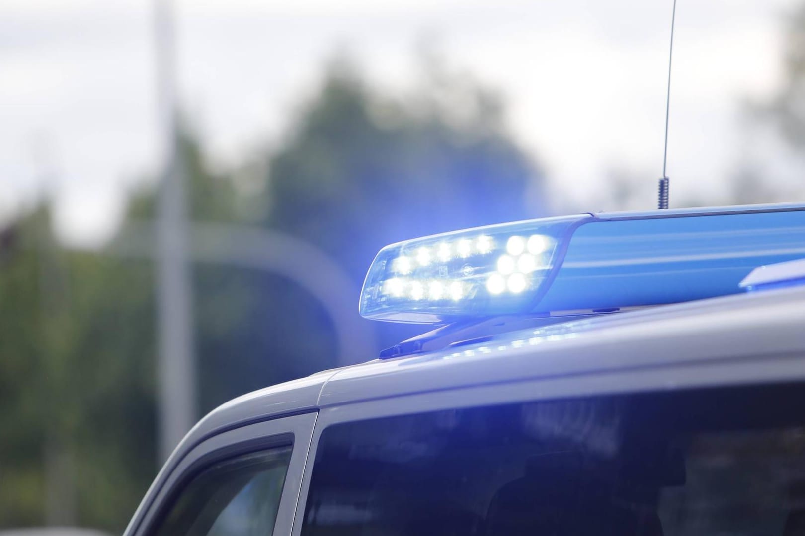 Ein Blaulicht leuchtet auf einem Polizeiauto (Symbolbild): Die Polizei hat die Ermittlungen wegen Brandstiftung, Sachbeschädigung und Volksverhetzung aufgenommen.