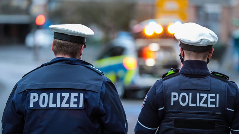 Zwei Beamte mit der Aufschrift "Polizei" auf dem Rücken (Symbolbild): In Leverkusen ermittelt der Staatsschutz nach Hakenkreuz-Graffiti.