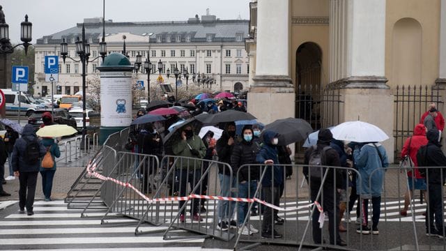 Menschen warten in einer Schlange vor dem Warschauer Rathaus auf ihre Impfung. Menschen warten in einer Schlange vor dem Warschauer Rathaus auf ihre Impfung.