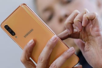 Eine Frau tipp auf einem Samsung-Smartphone (Symbolbild): Mit Steuercodes können Sie versteckte Funktionen Ihres Smartphones nutzen.