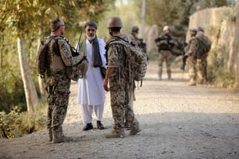 Bundeswehrsoldaten sprechen mit einem Mann in Afghanistan: Sogenannte Ortskräfte helfen den Streitkräften vor Ort, nun wollen viele von ihnen nach Deutschland.