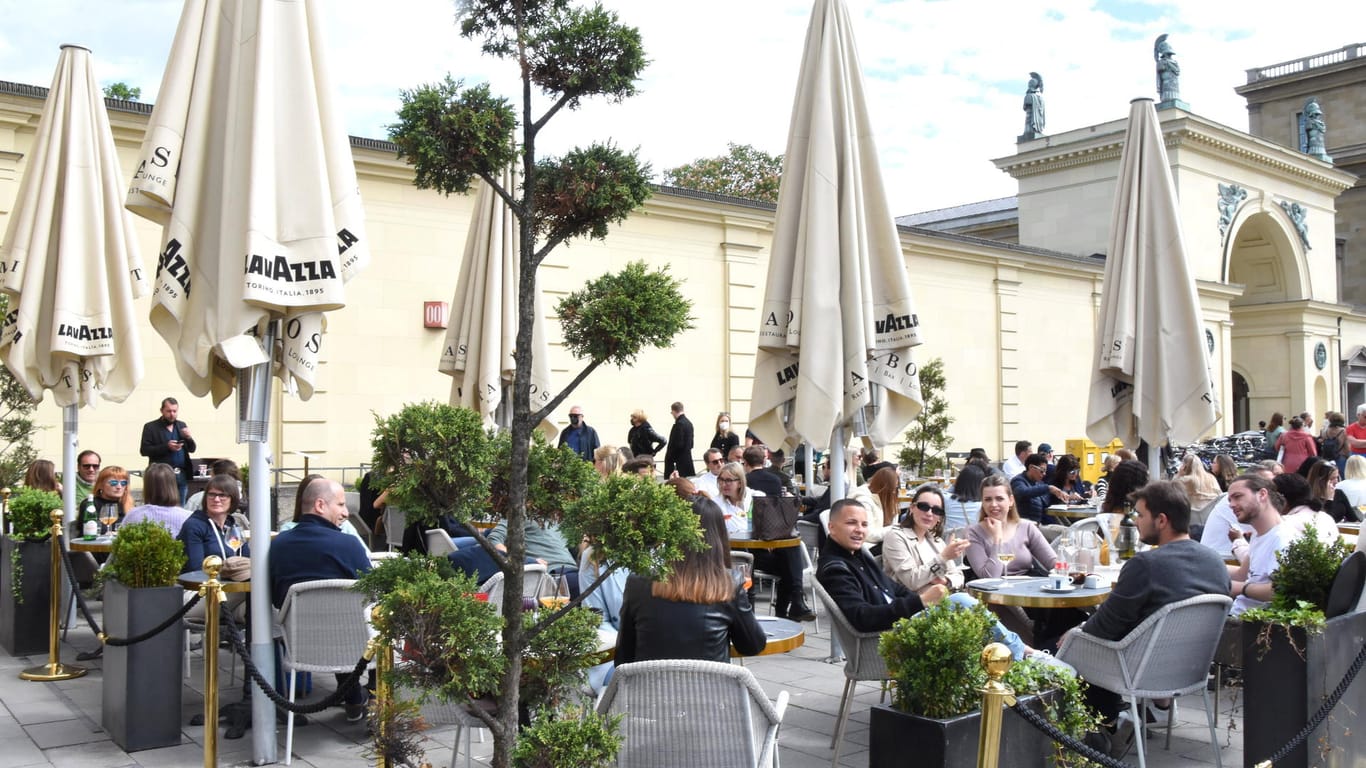 Menschen sitzen in einem Café in München: Die Außengastronomie ist schon geöffnet, bald könnten neue Lockerungen dazu kommen.