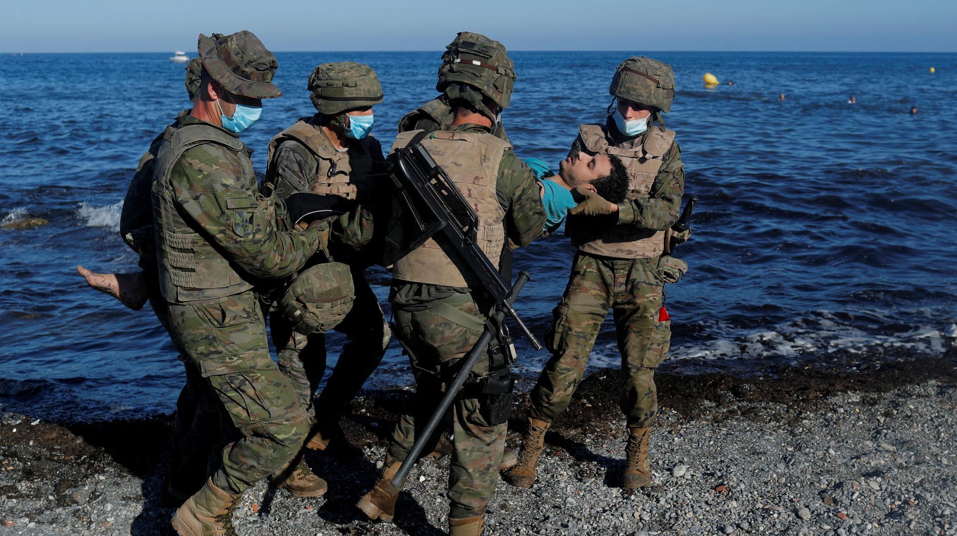 Dramatische Szenen: Spanische Soldaten tragen einen völlig erschöpften jungen Marokkaner vom Strand fort.