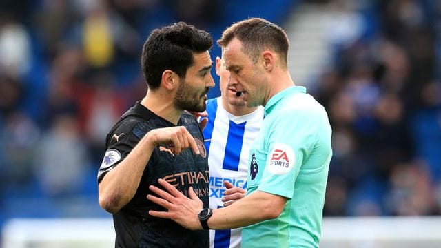 Ilkay Gündogan (l) von Manchester City im Gespräch mit Schiedsrichter Stuart Attwell.