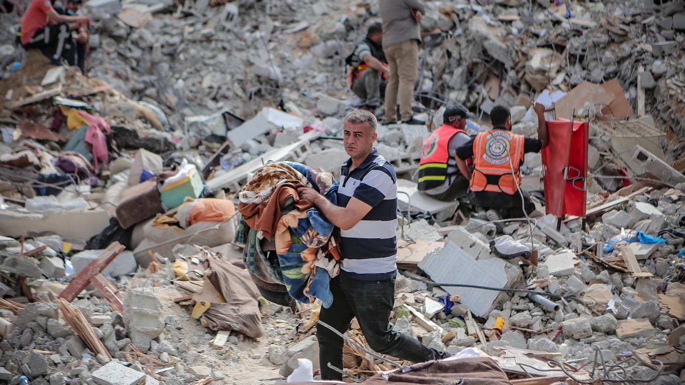 Nach Raketenbeschuss aus Israel auf die dicht besiedelte Stadt Gaza: Männer suchen am Sonntag nach Menschen in den Trümmern.