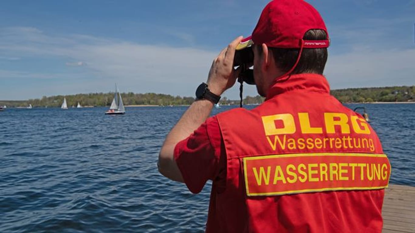 Ein Mitglied der Deutschen Lebensrettungs-Gesellschaft (DLRG) beobachtet die Boote auf dem Wannsee.