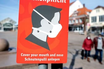 Ein Schild mit der Aufschrift "Maskenpflicht" hängt auf dem Marktplatz in der Innenstadt von Aurich.