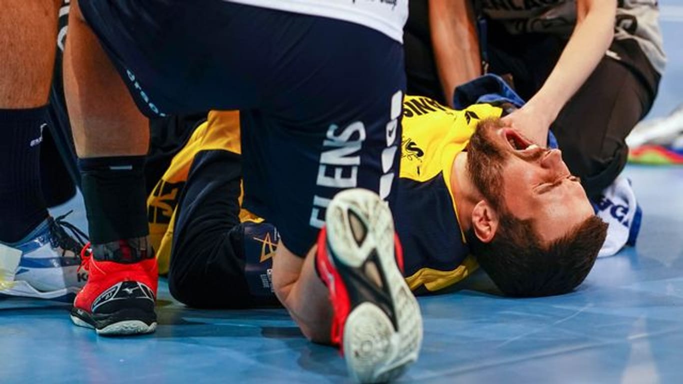 Flensburgs Benjamin Buric liegt verletzt mit schmerzverzerrtem Gesicht auf dem Spielfeld.