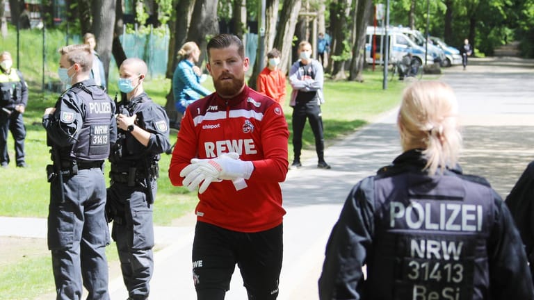 Torwart Timo Horn läuft zwischen Beamten hindurch: Das Abschlusstraining vor dem Spiel am Pfingstsamstag sicherten zahlreiche Polizisten ab.