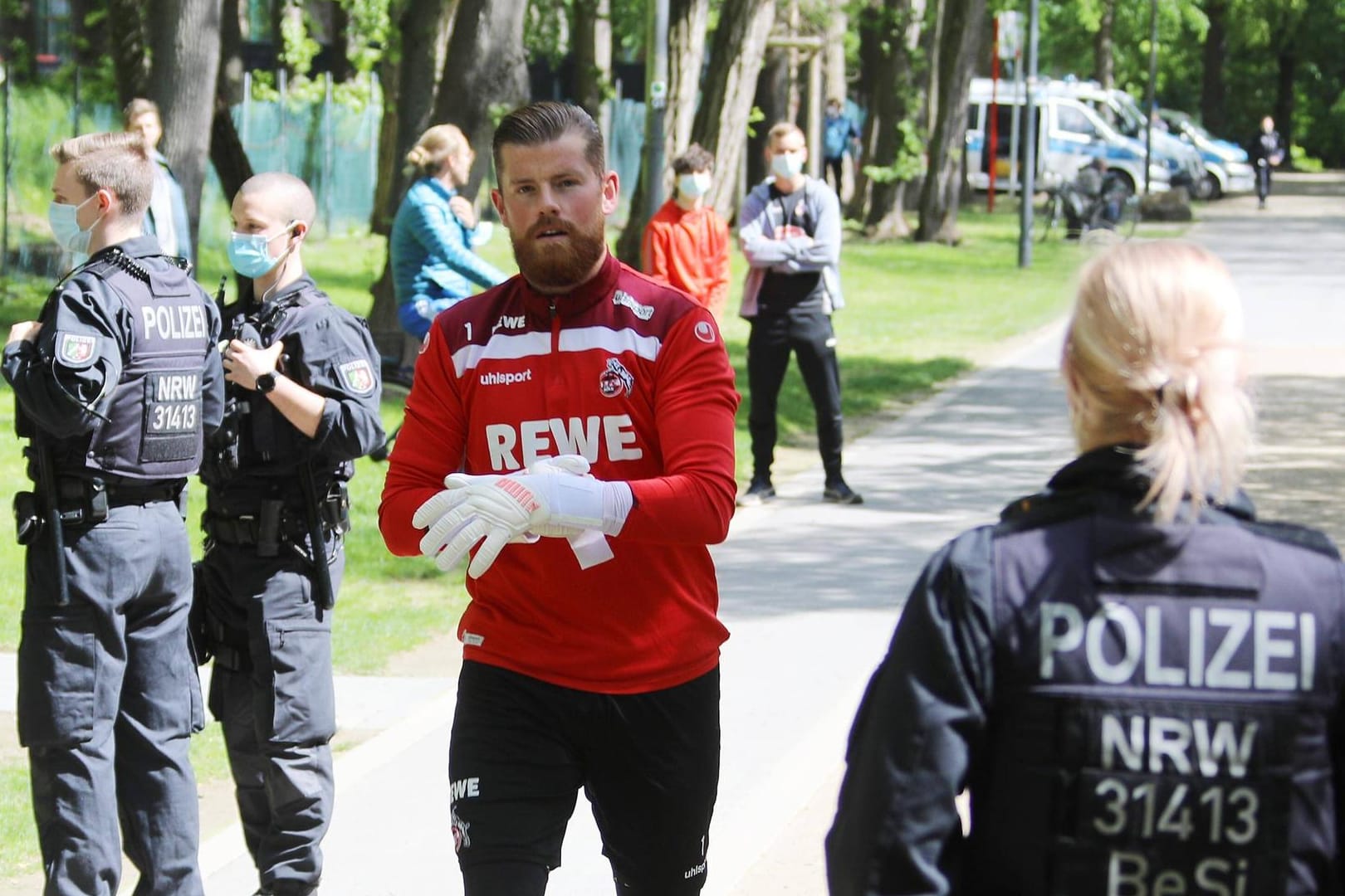 Torwart Timo Horn läuft zwischen Beamten hindurch: Das Abschlusstraining vor dem Spiel am Pfingstsamstag sicherten zahlreiche Polizisten ab.