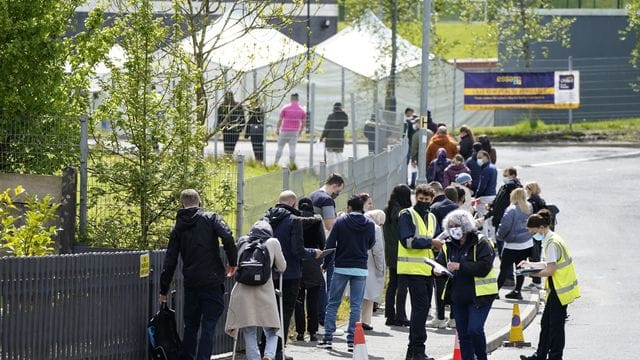 Menschen warten in einer Schlange vor dem mobilen Covid-Impfzentrum an der ESSA-Akademie in Bolton.