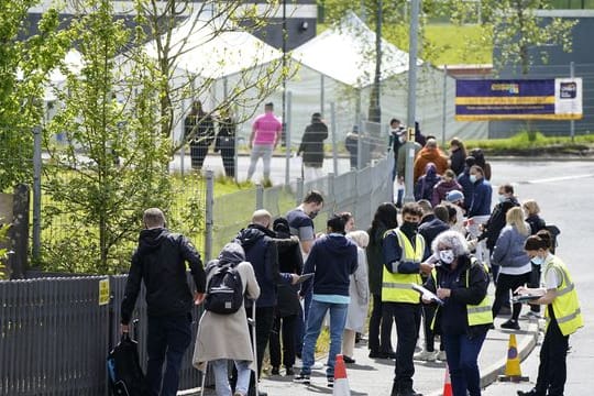 Menschen warten in einer Schlange vor dem mobilen Covid-Impfzentrum an der ESSA-Akademie in Bolton.