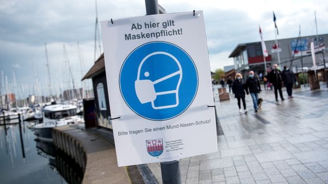 Ein Schild mit der Aufschrift "Ab hier gilt Maskenpflicht" hängt an der Promenade. Ein Schild mit der Aufschrift "Ab hier gilt Maskenpflicht" hängt an der Promenade.