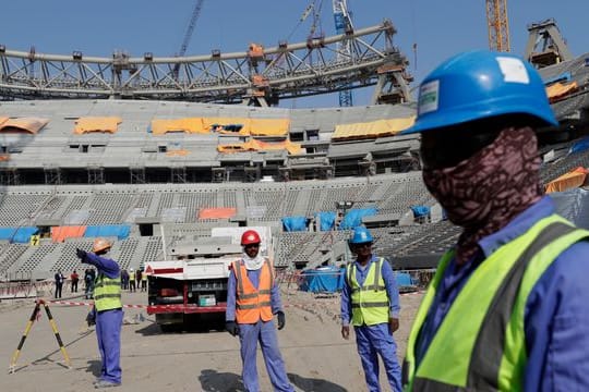 Bauarbeiter arbeiten am Lusail-Stadion, einem der Stadien der WM 2022.