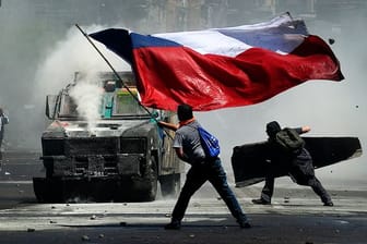 Flagge und Wasserwerfer: Momentaufnahme eines Protests in Chile gegen soziale Ungleichheit und die Regierung.
