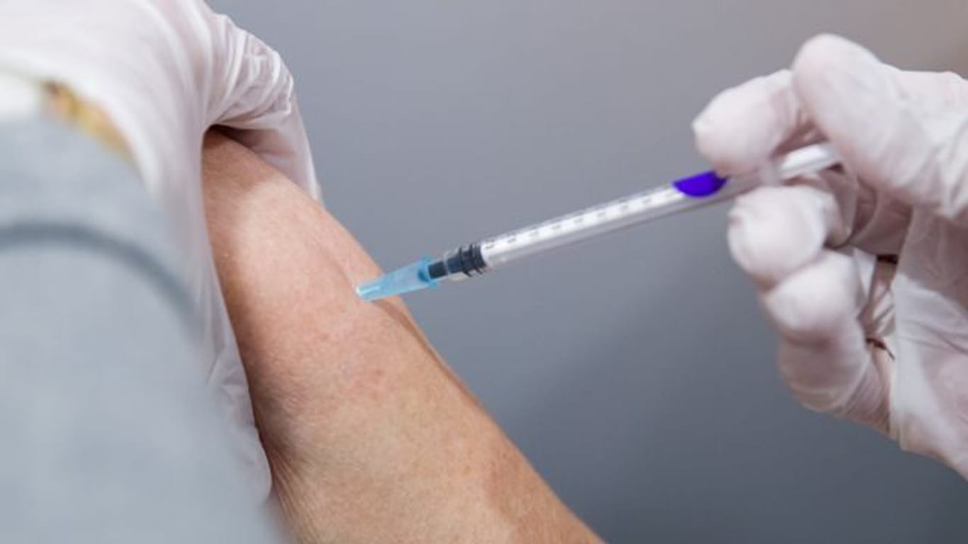 Ein Mann wird von einer medizinischen Fachkraft in einem Impfzentrum gegen das Coronavirus geimpft.