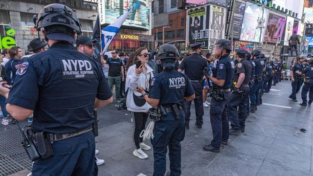 Polizisten stellen sich bei einem Zusammenstoß zwischen Unterstützern der Palästinenser und Unterstützern von Israel auf dem Times Square. Polizisten stellen sich bei einem Zusammenstoß zwischen Unterstützern der Palästinenser und Unterstützern von Israel auf dem Times Square.