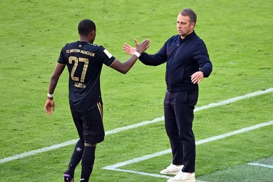 Bayern-Trainer Hansi Flick (r) bedankt sich bei David Alaba nach dessen Auswechslung.