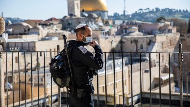 Ein israelischer Polizist mit Mundschutz steht in der Altstadt Wache. Ein israelischer Polizist mit Mundschutz steht in der Altstadt Wache.