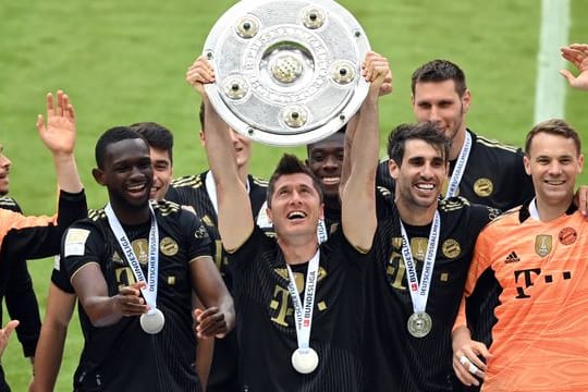 Bayern-Stürmer Robert Lewandowski (M) mit der Meisterschale.