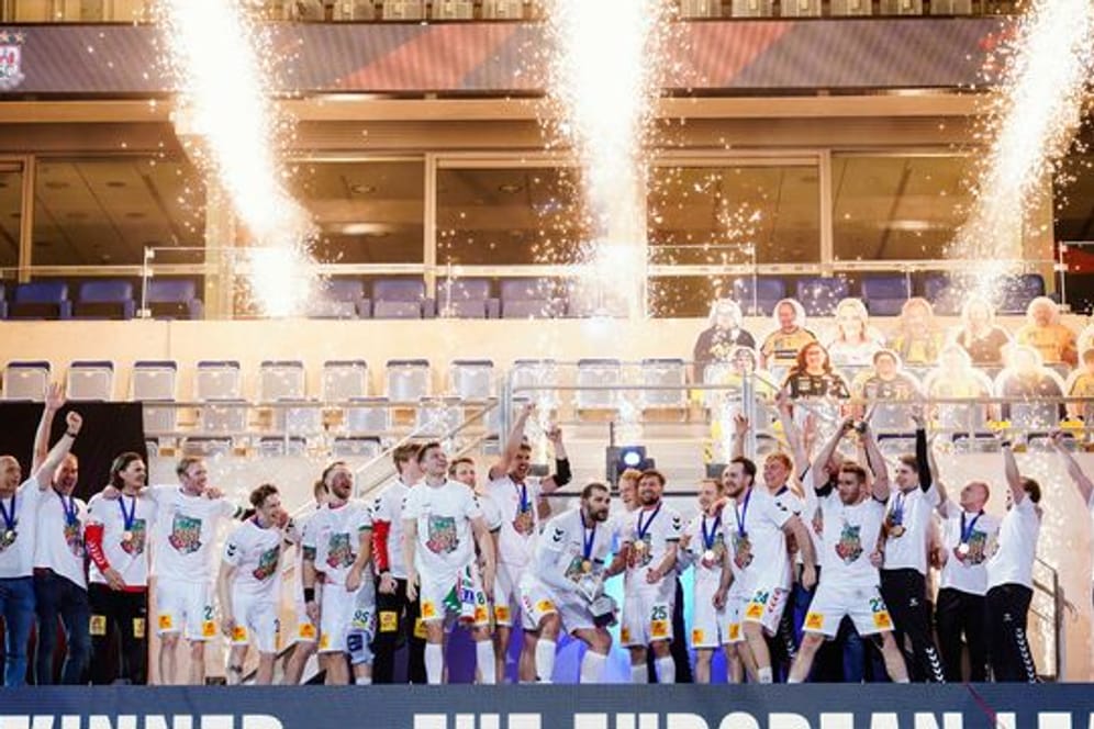 Magdeburgs Mannschaft feiert mit dem Siegerpokal den Finalsieg über die Füchse Berlin.